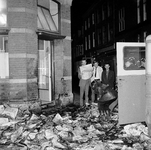 128636 Afbeelding van de ravage na het in brand steken door vandalen van een partij kranten bij het kantoor van het ...